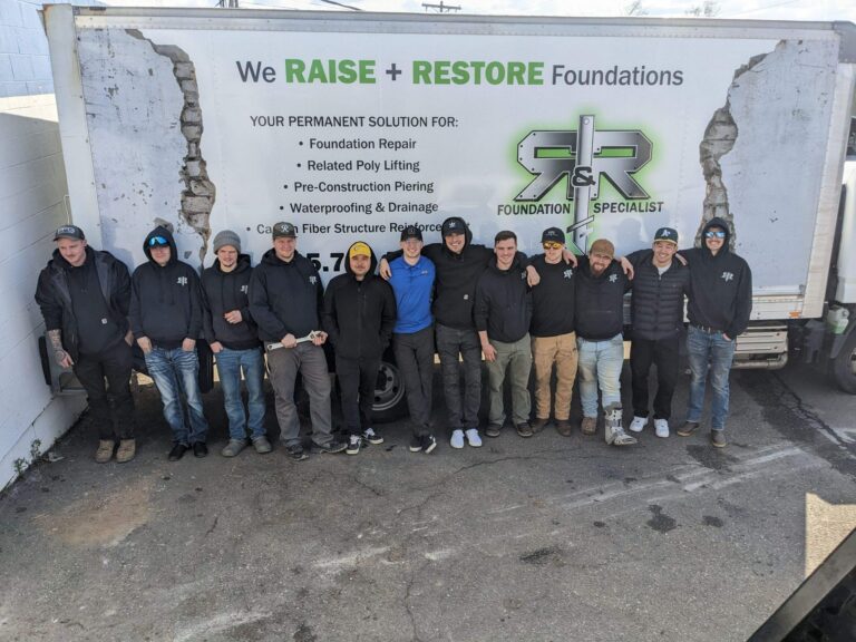 group of men in front of R&R white moving truck, men wearing all-black R&R sweatshirts